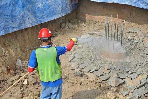 Construction workers spraying the anti termite chemical treatment to the pile cap